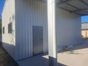 Door leading into medium sized white shed