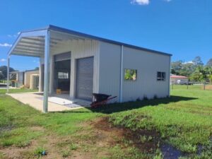 Skillion roof shed with three roller door entries and two windows