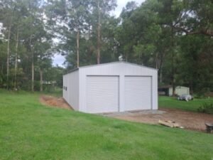 Small backyard shed with two roller doors