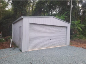 Grey colorbond shed with roller door large enough to fit two cars.