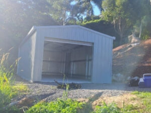 Small storage shed built on flat ground between uphill and downhill slopes