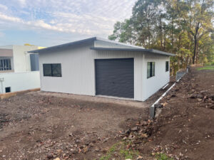 Dual skillion roof shed with roller door wide enough for one car.